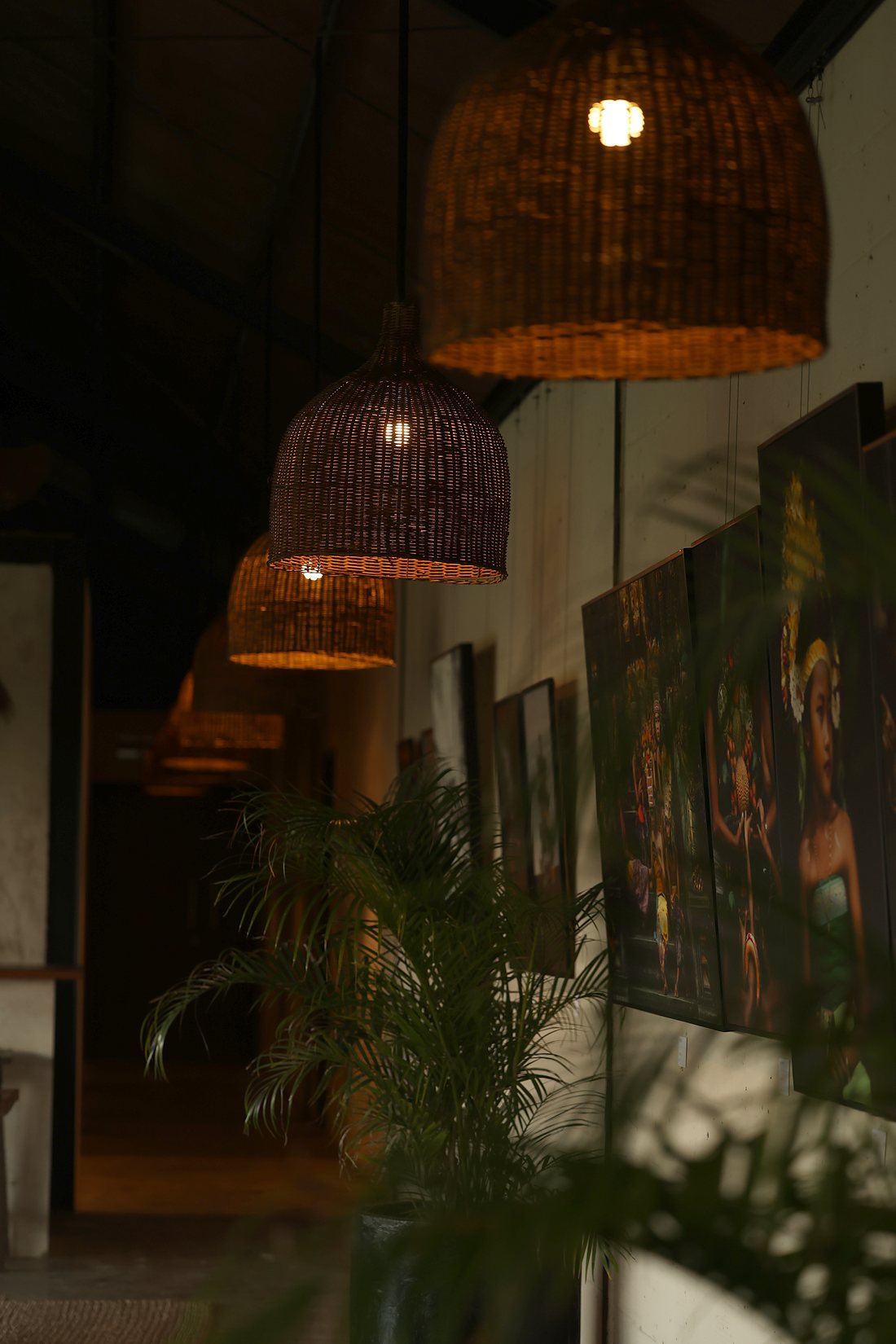 Rattan lamps lit above the photographs on the lounge wall