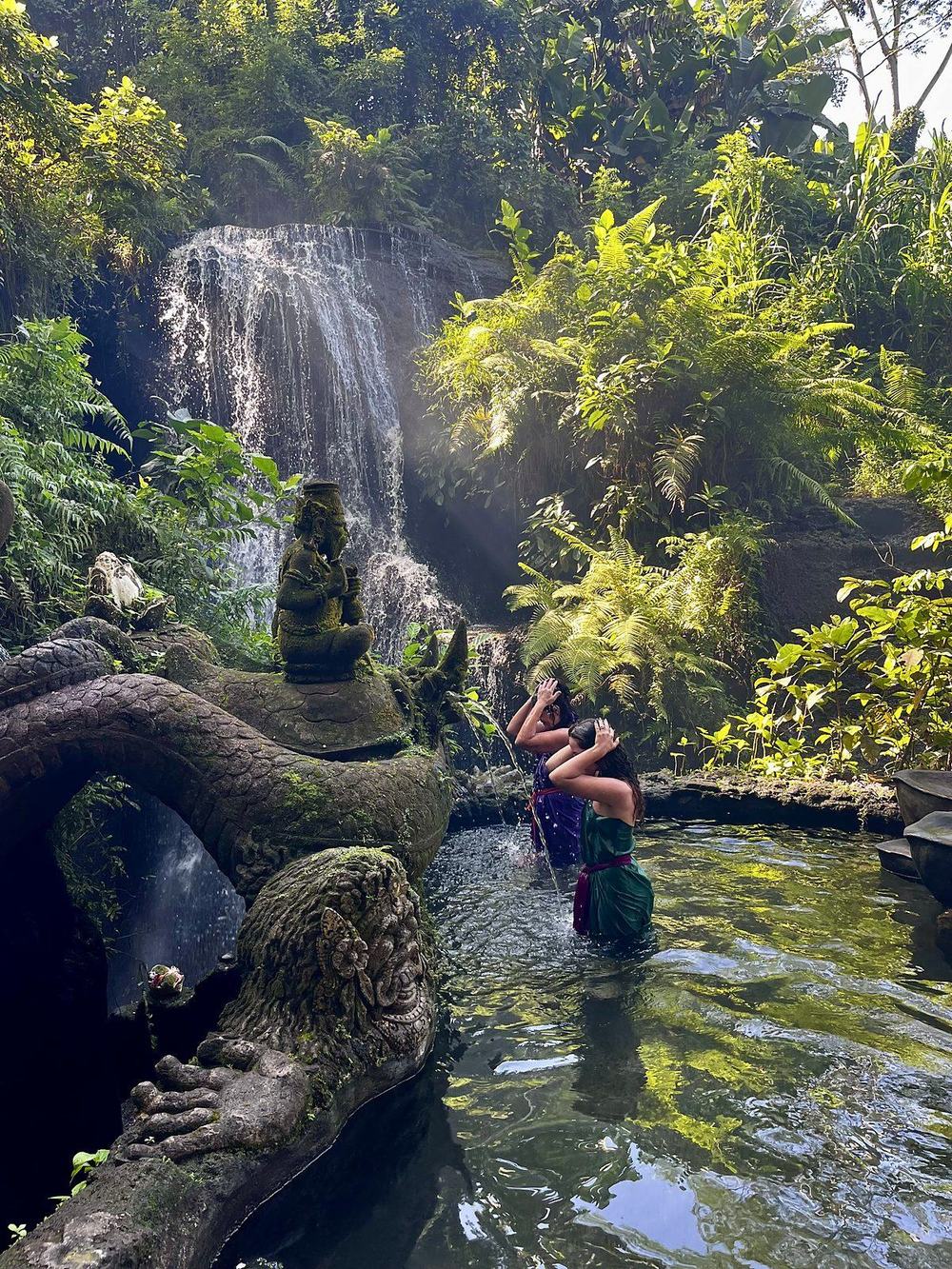 The waterfall pool at Taman Beji Griya with the carved dragon on the rocks