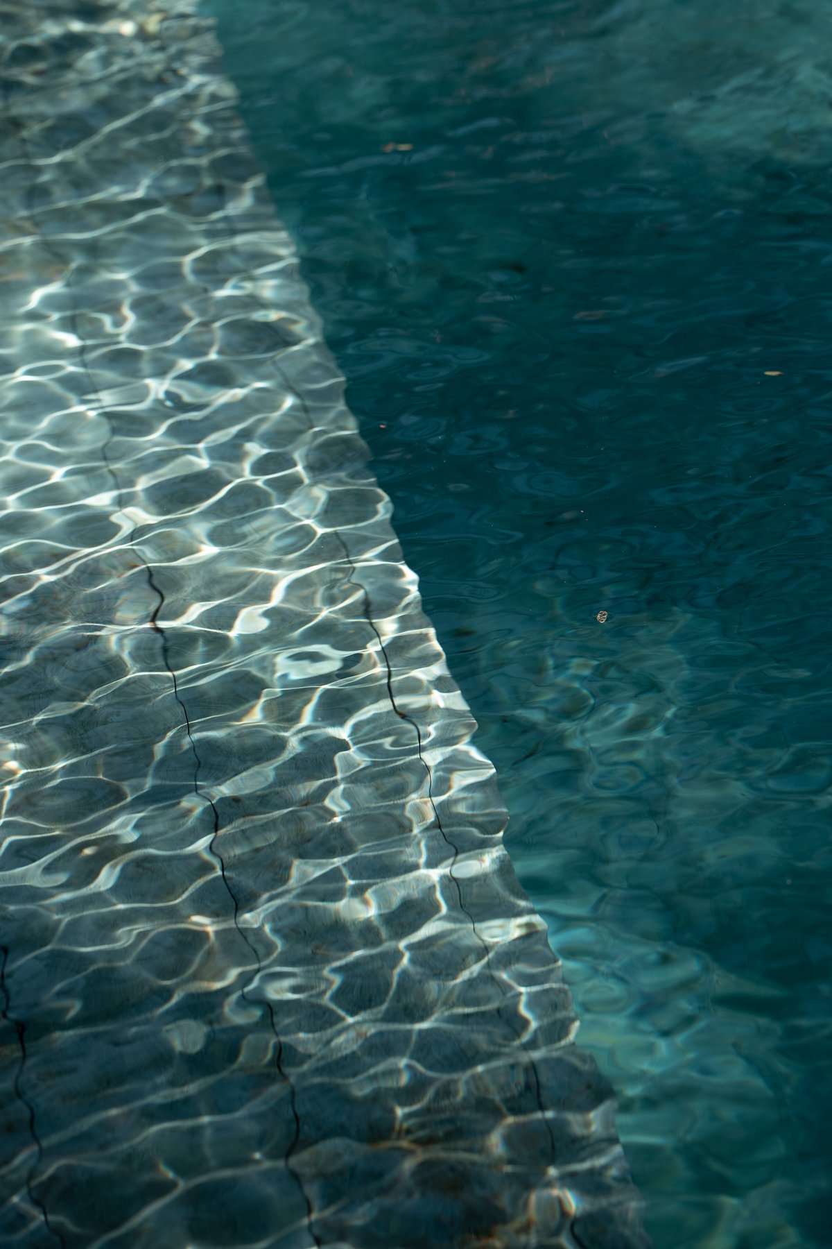 Sunlight rippling over the stone steps of the pool