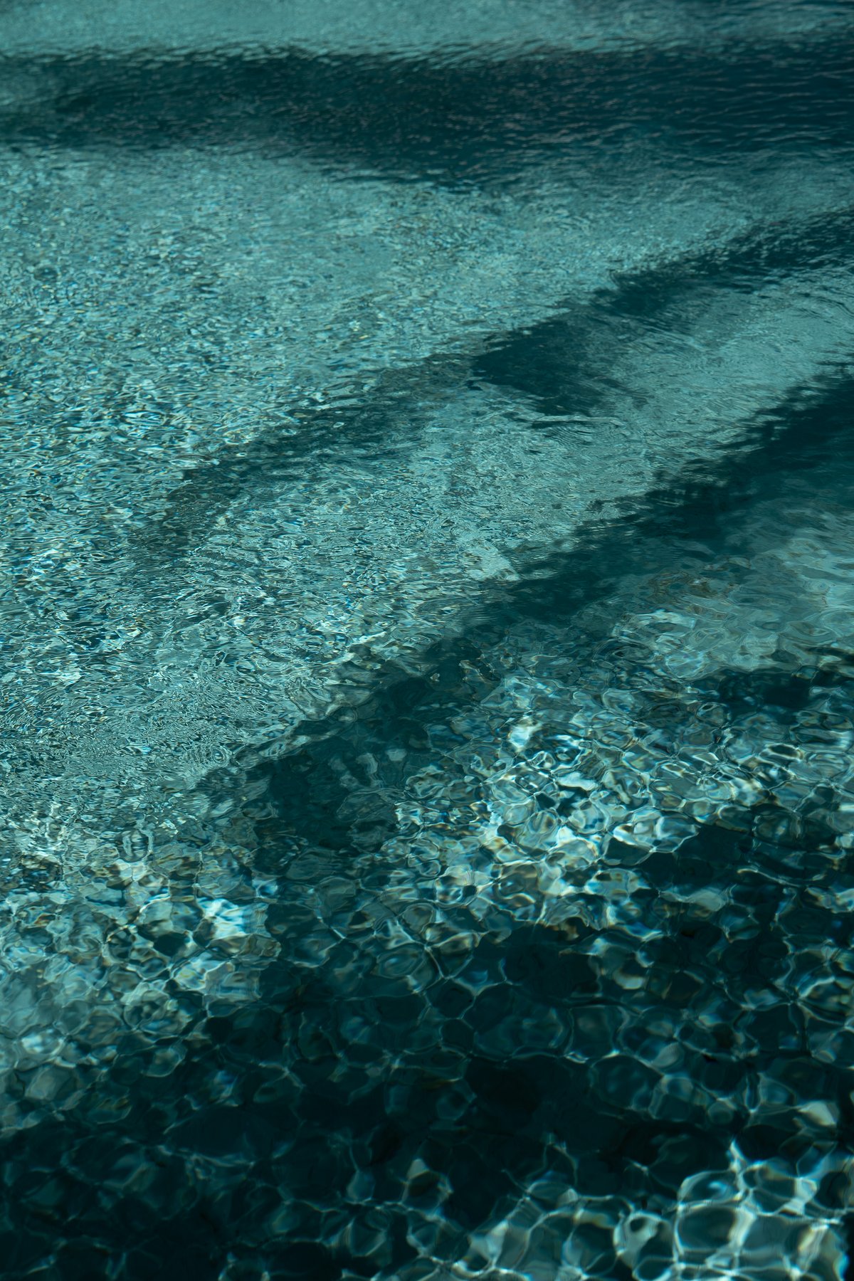 Clear turquoise water over the pool floor