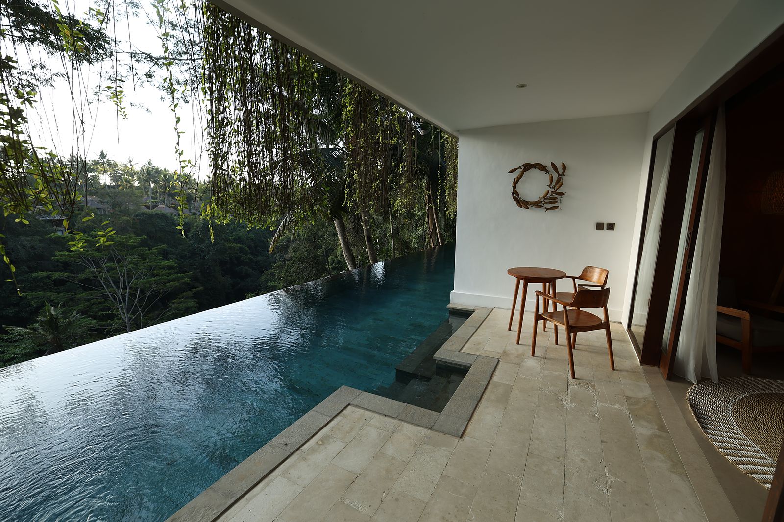 The Premiere pool terrace: two chairs, a small table and the jungle