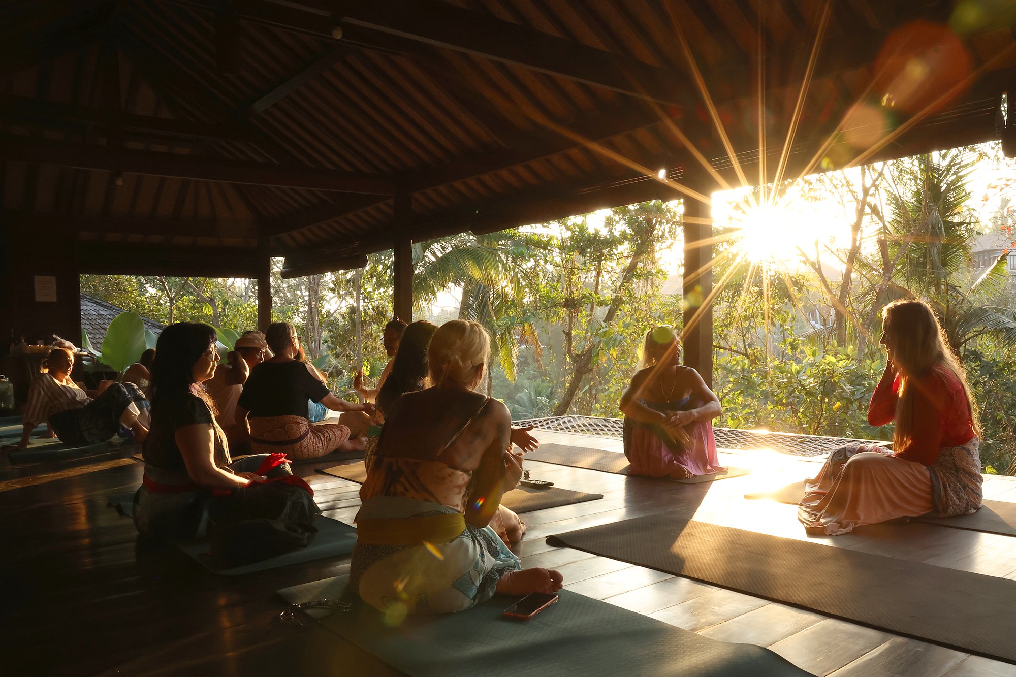 An evening class in the shala at sunset, the net over the valley behind